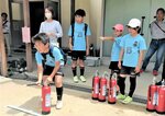 訓練用消火器を使って操作法を学ぶ参加者