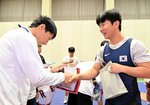 記念品を交換して握手を交わす両国の選手ら＝５日、米子市東福原８丁目の米子産業体育館