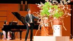 山城さんの演奏をバックに大作を仕上げる肥原さん（中央）