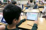 　速く走るための走法をタブレット端末で比較する子ども＝１０月、東京都目黒区立駒場小