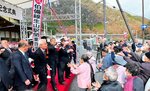 紅白の餅をまく関係者ら＝２８日、日南町生山のＪＲ生山駅
