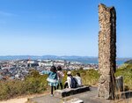 トーテムポールの石柱が建つ日本台で眺望を楽しむ親子連れ