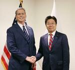 　握手する加藤財務相（右）とベセント米財務長官＝２４日、ワシントン（財務省提供）