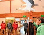 スタッフ（右）からコウノトリの生態の話を聞くなどプログラムを体験する参加者＝１日、豊岡市祥雲寺の市立コウノトリ文化館