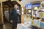 　自身が営む「冒険研究所書店」で本を紹介する荻田泰永さん＝２０２５年３月、神奈川県大和市