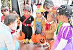 仮装姿で店主に「トリック・オア・トリート」と唱える子どもたち