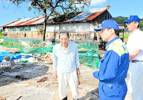 半壊した旧鶏舎の前で金沢さん（左）から被害状況を聞く平井知事（中央）＝１日、伯耆町立岩