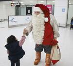 　フィンランドから成田空港に到着し、子どもと握手するサンタクロース＝12月１日