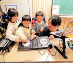 ターンテーブルに触ってＤＪ気分を楽しむ子どもたち