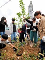 観音像のそばにソメイヨシノを植樹する学院生ら