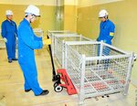 解体作業で発生する廃棄物を保管する容器を設置する協力会社の社員ら＝２９日、松江市鹿島町
