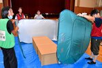 市職員（左）と一緒に簡易パーティションを設営する住民ら＝１０日、鳥取市篠坂の東郷小