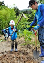 土を掘り、苗を植える参加者＝２５日、三朝町高橋