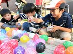 屋台のヨーヨー釣りに興じる子どもたち＝２０日、倉吉市明治町
