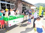 野菜販売で地域住民と交流する子どもたち