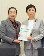 　選択的夫婦別姓を巡り、自民党の推進派議員連盟の土屋品子会長代行（左）に、民法改正案要綱を手渡す立憲民主党の辻元清美代表代行＝１５日午後、国会