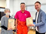 こども食堂の担当者（左）に日南町産のコメを寄贈した秋田理事長（中央）