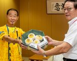「阪神タイガース優勝まちがい梨」を田中市長（右）に手渡す板持さん＝１９日、安来市役所