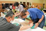 小原さん（左）から助言をもらいながら手ろくろ体験をする参加者＝１３日、倉吉市上井町１丁目の日本海新聞中部本社ホール