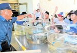 威勢良く手を上げて魚を競り落とす児童たち＝１０日、香美町香住区の香住高