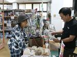 　地域の人々の健康状態なども気に掛けながら接客する「浜共同店」店主の山城吉秀さん（右）＝沖縄県国頭村