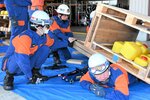 ジャッキを使って下敷きになった人の救助を試みる団員ら