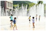 噴水の水を浴びてはしゃぐ子どもたち＝１３日、倉吉市駄経寺町の倉吉パークスクエア