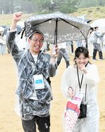 借り人競争で、雨の中２人で傘を差し、ゴールする男女＝２４日、鳥取市浜坂の鳥取砂丘