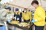 屋台の実演販売で焼きそばを作るクラブ会員