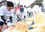 温かい豚汁を受け取るランナーたち＝１６日、鳥取市国府町宮下の宮下地区公民館