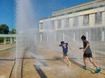 焼けるような日差しの下、噴水の水で涼をとる子どもたち＝２日、鳥取県倉吉市の倉吉パークスクエア