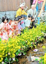 願いを込めた絵馬を玉川に流す子どもたち＝７日、倉吉市の白壁土蔵群