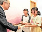 深沢市長（左）に集めた募金を手渡す松本さん（右）と伊吹さん