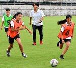 児童とサッカーを楽しむ大部さん（中央）＝２２日、鳥取市蔵田のＡｘｉｓバードスタジアム