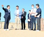 平井知事（左）から鳥取砂丘の魅力について説明を受けるダウンズ氏（同２人目）＝１７日、鳥取市福部町湯山