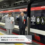　大リーグカラー仕様にラッピングされた特別列車の出発式に臨む村上雅則さん（右）＝７日午後、東武鉄道の浅草駅