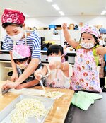 生地を切ってほぐして。力を合わせてうどん打ちに挑戦する参加者たち＝２８日、新温泉町丹土の県立但馬牧場公園