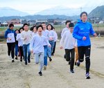 子どもたちと校庭を走る岡本さん（右）