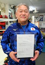 神戸学院大客員教授就任が決まり、委嘱状を手にする伊田武志さん＝米子市久米町のシュガーナックルボクシングジム