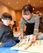 図鑑を見て楽しむ親子連れ