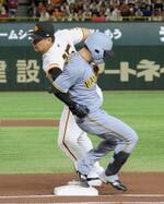 　６日の阪神戦の一回、中野（右）と一塁上で交錯する巨人の岡本＝東京ドーム