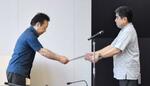 　防衛省沖縄防衛局の伊藤晋哉局長（左）に抗議文を手渡す沖縄県の池田竹州副知事＝１９日午後、沖縄県庁