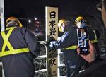 　ＪＲ東根室駅ホーム上の「日本最東端の駅」と記された表示を取り外す作業員＝１４日夜、北海道根室市