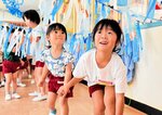 天の川に見立てたテープの下をくぐって、お菓子取りに挑戦する園児たち＝７日、新温泉町の浜坂認定こども園