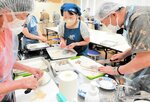 講師（中央）に教わりながらイカをさばく参加者＝香美町の香住文化会館
