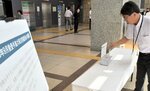 募金箱の設置後、早速募金をする県職員＝２５日、鳥取県庁
