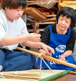 山本会長（右）の指導を受けながら小骨を取り付ける生徒