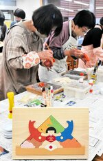 金太郎やコイなど端午の節句を象徴する組み木飾り（手前）づくりに取り組む参加者＝１９日、香美町村岡区和池の木の殿堂