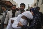 　３月２１日、ガザ北部ガザ市で、イスラエルの攻撃により殺害された１１歳の娘の遺体を運ぶ父親（ＡＰ＝共同）