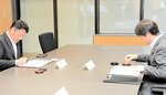 協定書に押印する坪内理事長（左）と上定市長